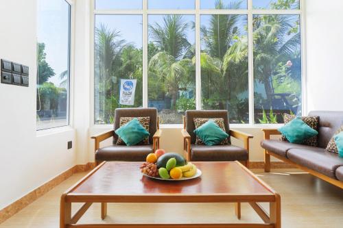 Feridhoo西维内克斯旅馆的客厅配有沙发和桌上一碗水果