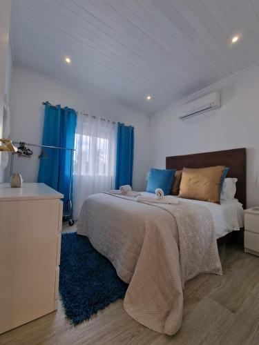 拉戈斯Quinta do Baía的一间卧室配有一张带蓝色窗帘的大床