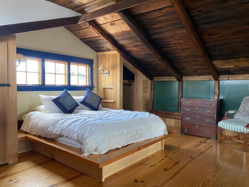 纽波特Magical Post And Beam Loft Downtown Newport!的一间卧室设有一张大床,拥有蓝色的墙壁和木制天花板。