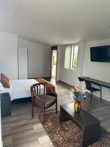 波帕扬PERUGINO´S HOTEL GALERIA的一间卧室配有一张床、一张桌子和一把椅子