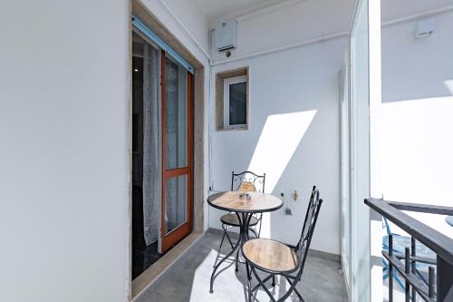 莱切Prezioso suites & rooms的房屋阳台上的小桌子和椅子