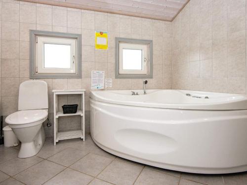 海默特8 person holiday home in Hemmet的浴室配有白色浴缸和卫生间。