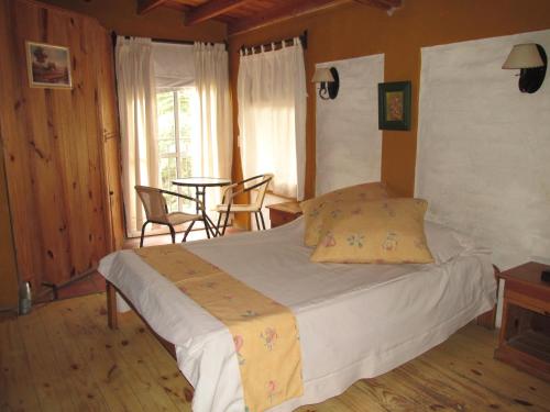 波特雷里约斯Cabañas Los Arreboles的卧室配有一张床和一张桌子及椅子