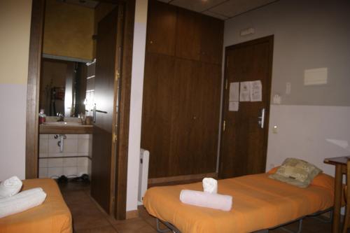 巴加HOTEL FAMILIAR BAGA的一间设有两张床铺和毛巾的房间
