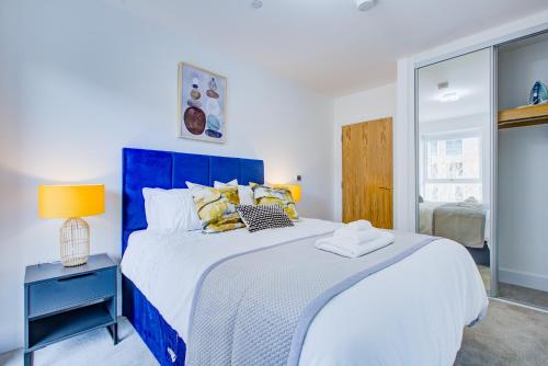 伦敦Luxe Apartment by Excel的卧室配有蓝色和白色的床和窗户。