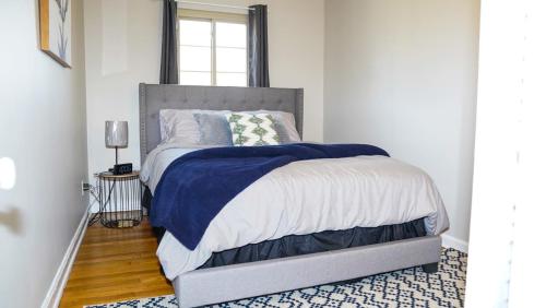 哥伦布Franklin Park 3BR Condo near Airport, Downtown, OSU的一间卧室配有一张带蓝白色毯子的床