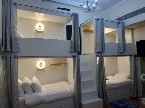 迪拜Shared Room in Dubai - D Bunkers Camp的两张双层床,位于带灯的房间
