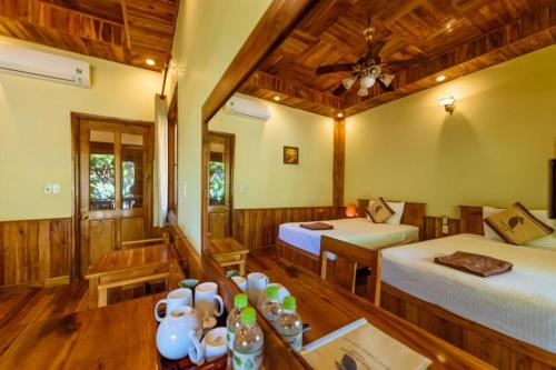 富国芒果海滩度假酒店的一间设有两张床和一张桌子的房间
