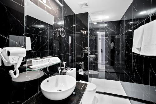西哈努克MLZ Apartments Sihanoukville的黑白浴室设有卫生间和水槽