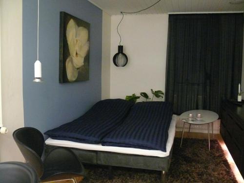 奥胡斯弗雷登斯万度假屋的一间卧室配有一张床和一张桌子及椅子