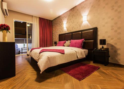 梅克内斯斯万尼酒店的卧室配有一张带粉红色枕头的大床