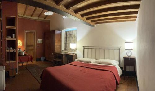 巴尔贝里诺瓦尔德尔萨托雷迪庞扎诺酒店的一间卧室配有红色床单和白色枕头。