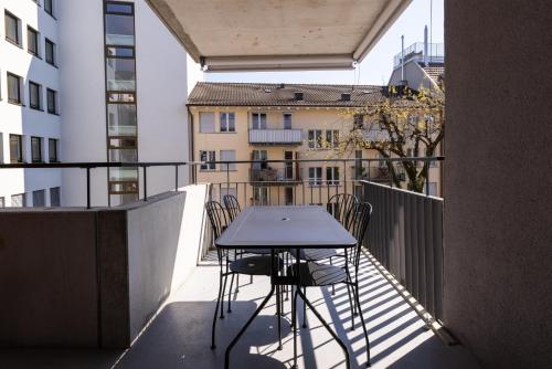 苏黎世EMA House Serviced Apartments Superior Seefeld的阳台配有桌椅。
