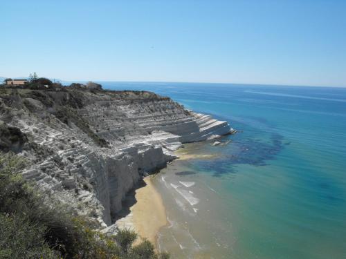 雷阿尔蒙特Appartamento Valle dei Templi的海洋旁岩石峭壁的空中景观