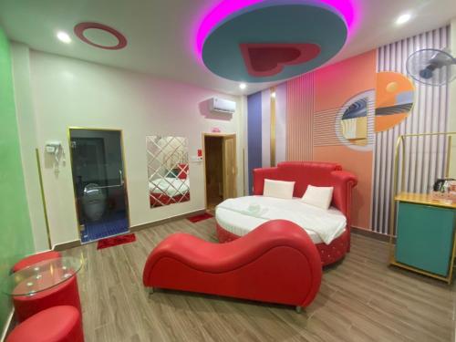 胡志明市HOTEL THU HÀ的一间卧室配有一张床和一张红色椅子