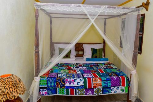 迪亚尼海滩Gästehaus Diani的一间卧室配有一张带天蓬的床
