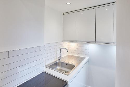 惠特比Apartment 1 - Khyber Lodge Apartments的厨房配有水槽和白色橱柜
