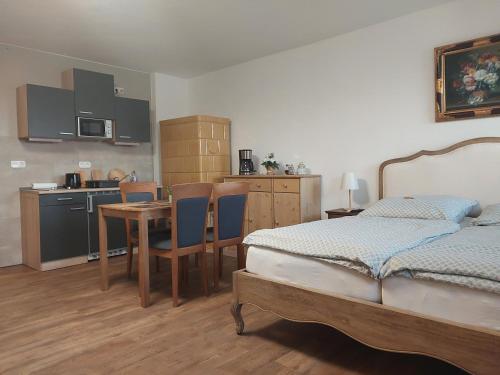Usedom TownJennys Hofladen的一间卧室配有一张床铺和一张桌子,还设有一间厨房