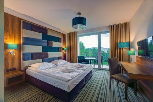 波拉齐克Solina Resort的酒店客房配有一张床、一张书桌和一张书桌。