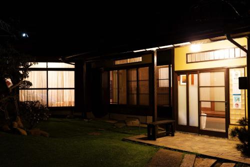 伊东伊豆の宿　静海的夜晚的房子,前面有长凳