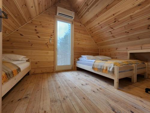 拉布卡Agro-Gala的小木屋卧室内的两张床,设有窗户