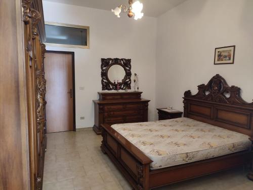 雷焦卡拉布里亚Campolo Apartment的一间卧室配有木床和镜子