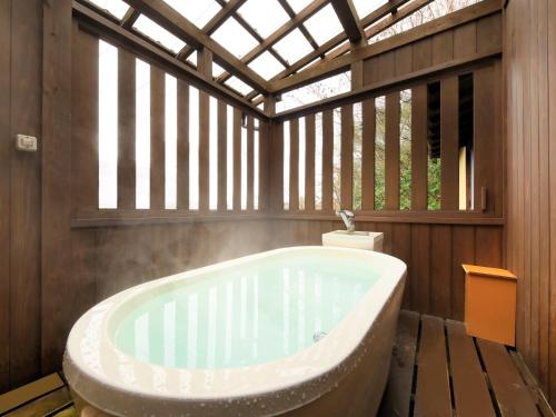 上山市绿党果亭时代雅酒店的带浴缸的浴室和窗户
