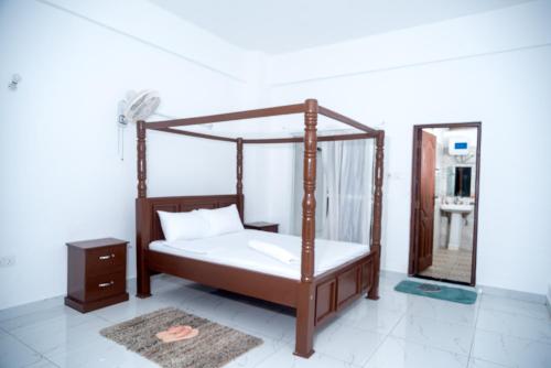 蒙巴萨Precious Moments Suite的一间卧室配有天蓬床和镜子