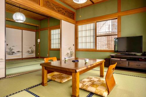 由布市Ryosou Makibanoie 18 years or older的客厅配有木桌和电视。
