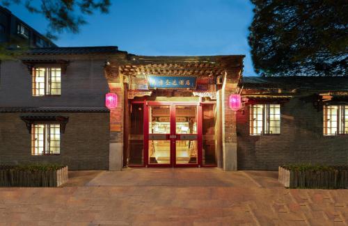 北京The East Hotel-Very close to the Drum Tower,The Lama Temple,Houhai Bar Street,and the Forbidden City,There are many old Beijing traditional hutongs around the hotel ,Experience the culture of old Beijing hutongs,Near Exit A of Shichahai on Metro Line 8的前方有红门的砖砌建筑