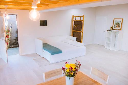 伊科德洛斯维诺斯Casita Gopal的白色的房间,配有一张床和花瓶