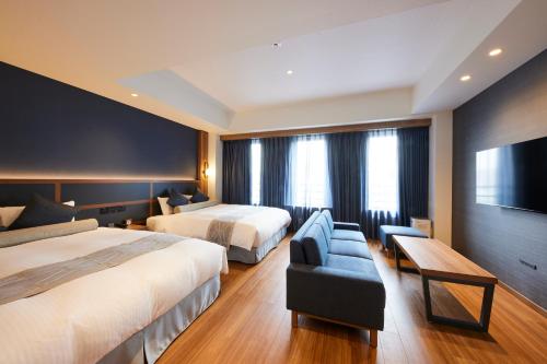 大阪HOTEL SAILS的酒店客房,设有两张床和一张沙发