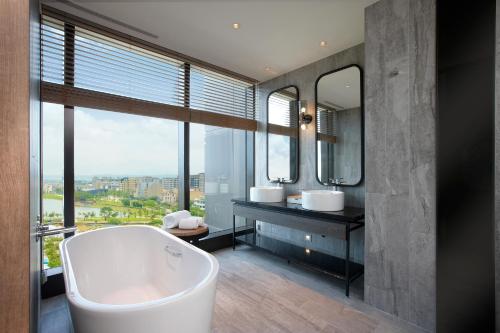 中坜和逸饭店桃园馆的带浴缸、两个盥洗盆和镜子的浴室