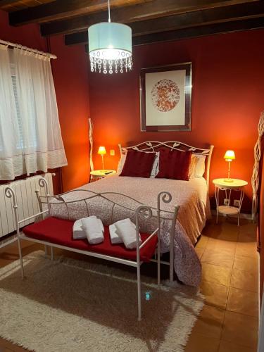 MiengoChalet Robayera a línea de playa的一间卧室配有一张红色墙壁和吊灯的床。
