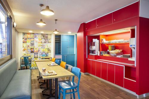 奥尔日河畔埃皮奈hotelF1 Epinay sur Orge的餐厅拥有红色的墙壁,配有桌椅