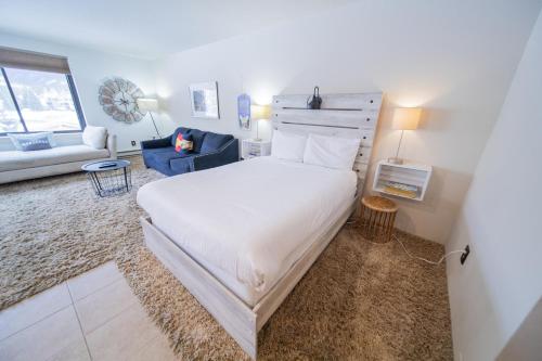 基斯通Edgewater 1436的卧室配有一张白色大床和一张蓝色椅子