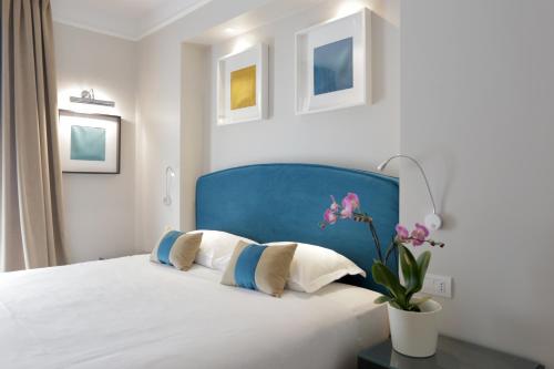 钱皮诺别墅套房酒店的一间卧室配有一张蓝色床头板的床