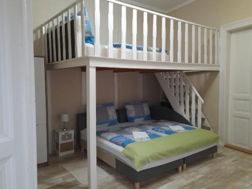 沙托劳尔尧乌伊海伊Edina Apartman的一间卧室设有双层床和楼梯。