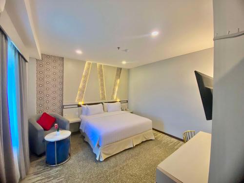 帕朗卡拉亚Best Western Batang Garing的配有一张床和一把椅子的酒店客房