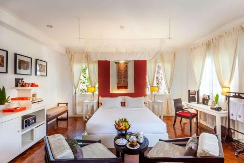 琅勃拉邦Angsana Maison Souvannaphoum Hotel的卧室配有白色的床和红色的墙壁