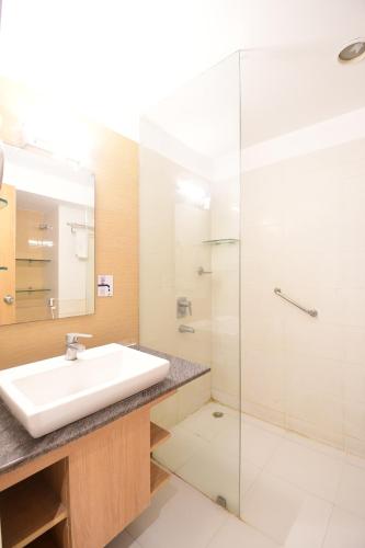 加尔各答The Xen Suites, Kolkata Airport的一间带水槽和玻璃淋浴的浴室