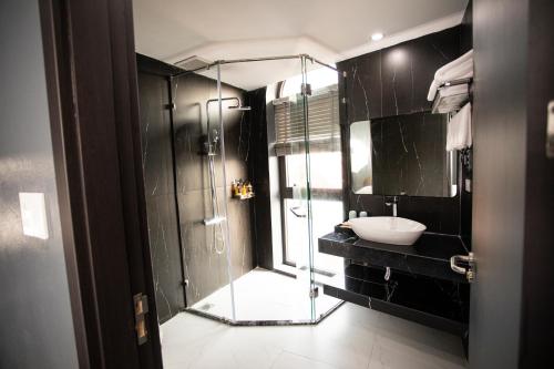 高平La Maison Boutique Hotel的一间带玻璃淋浴和水槽的浴室