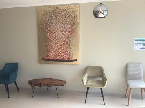 奥格斯堡A8卢卡斯酒店的一间设有椅子的房间和墙上的绘画