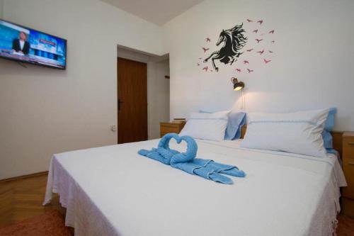尼亚卢卡Apartman Bačić的一间卧室配有一张带蓝色毛巾的床