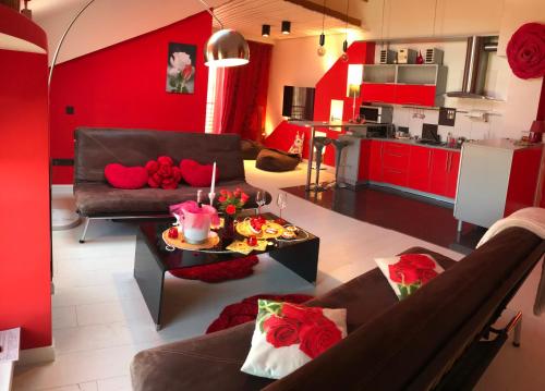 采西斯浪漫玫瑰酒店的客厅设有红色的墙壁、一张沙发和一张桌子