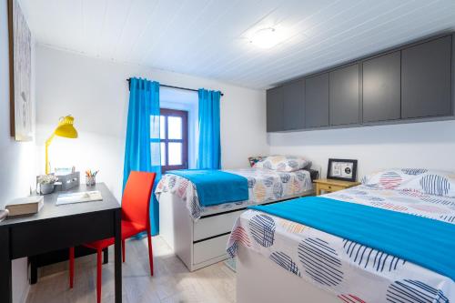 斯塔拉巴斯卡Holiday House Nova的一间卧室配有两张床、一张桌子和一张桌子