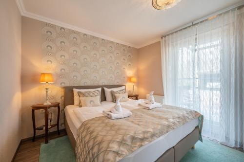 宾茨Appartement Am Park der Sinne & Am See的一间卧室配有一张大床和毛巾