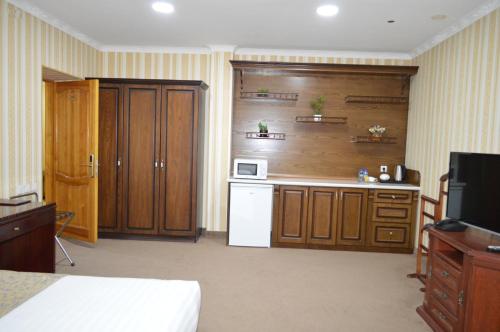 布哈拉KABIR HOTEL的厨房配有木制橱柜和白色冰箱。