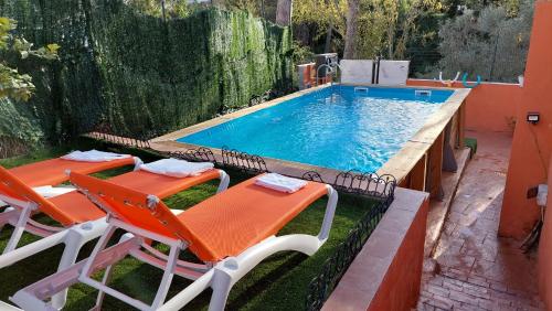 圣埃斯特万-德萨斯罗维拉斯Relax House Barcelone的一个带两把椅子和一张桌子的游泳池