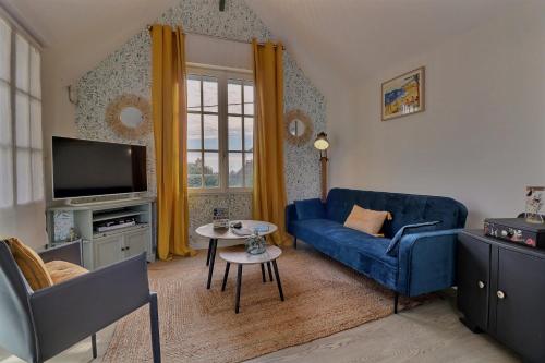 迪纳尔Les Mots Bleus的客厅配有蓝色的沙发和电视